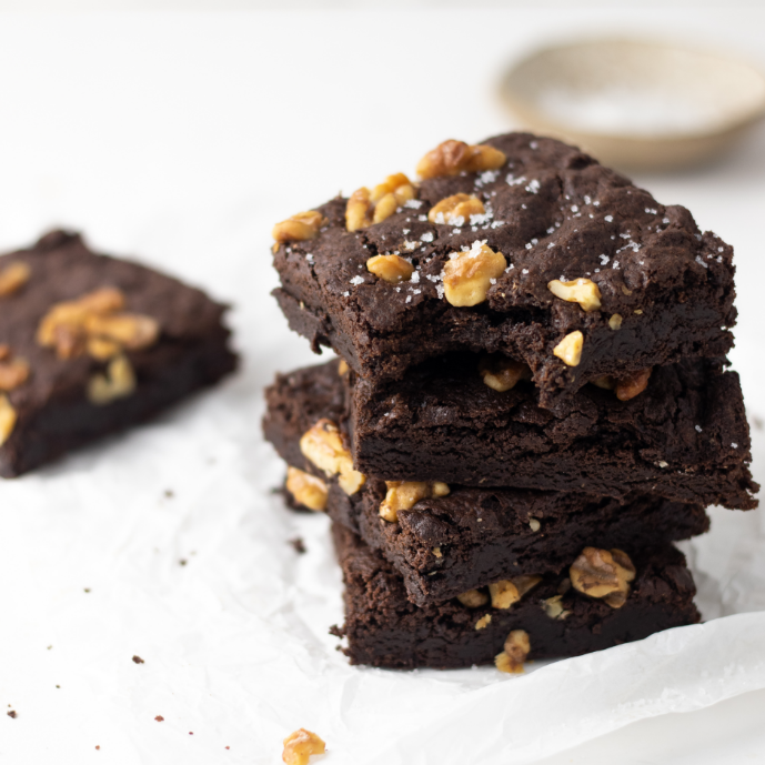 brownie em cubos posicionados um sobre o outro em um fundo branco