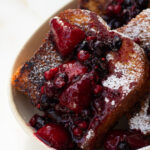 Delicious French toast on a plate with caramelized sugar topping and fresh berries.
